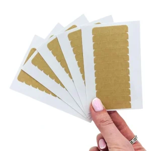 Hand holding 5 sheets of Hair Made Easi Easitape Extension Tape Tabs